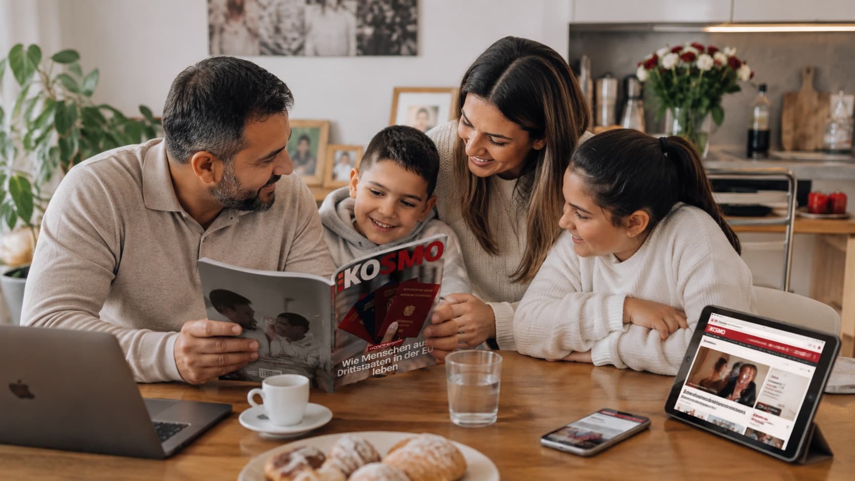 Eine Familie am Küchentisch: Eltern und zwei Kinder lesen gemeinsam im KOSMO-Heft, daneben Laptop, Tablet und Smartphone mit kosmo.at
